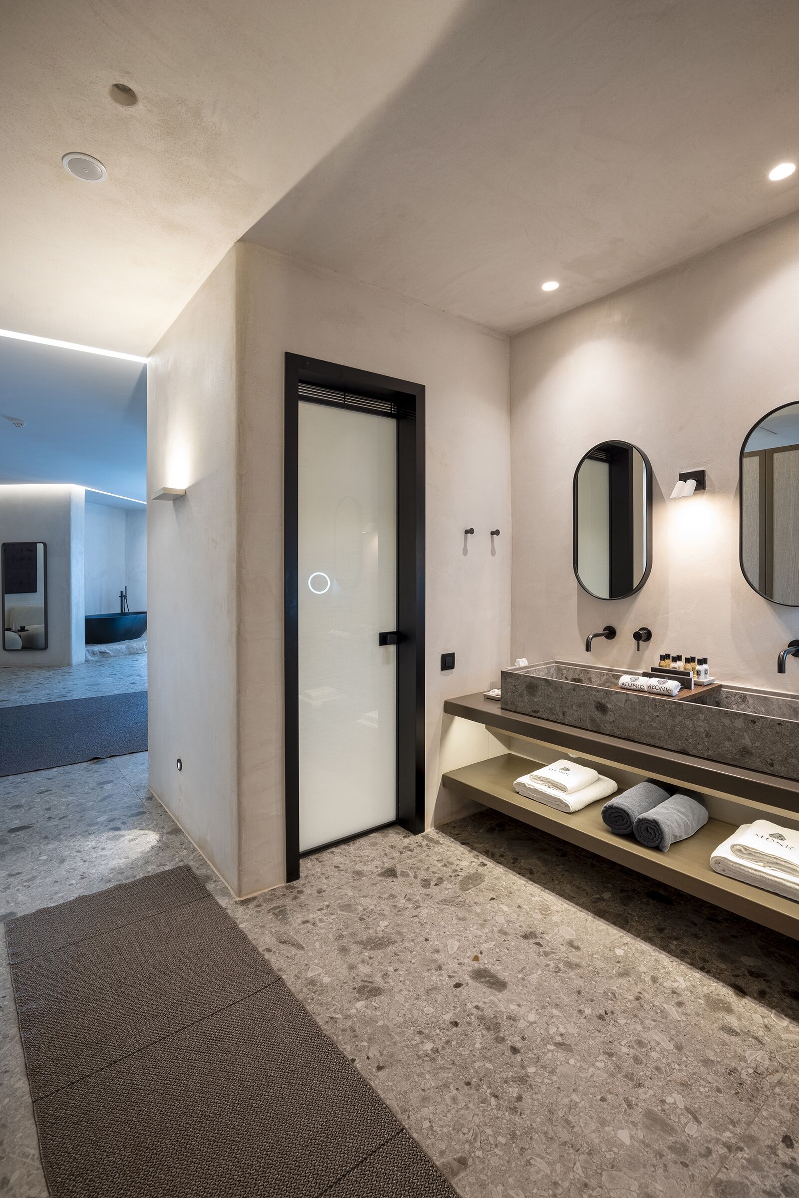 Un baño moderno con un espejo grande, un lavabo integrado y un perchero para toallas.