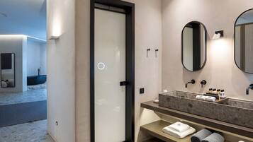 Un baño moderno con un espejo grande, un lavabo integrado y un perchero para toallas.