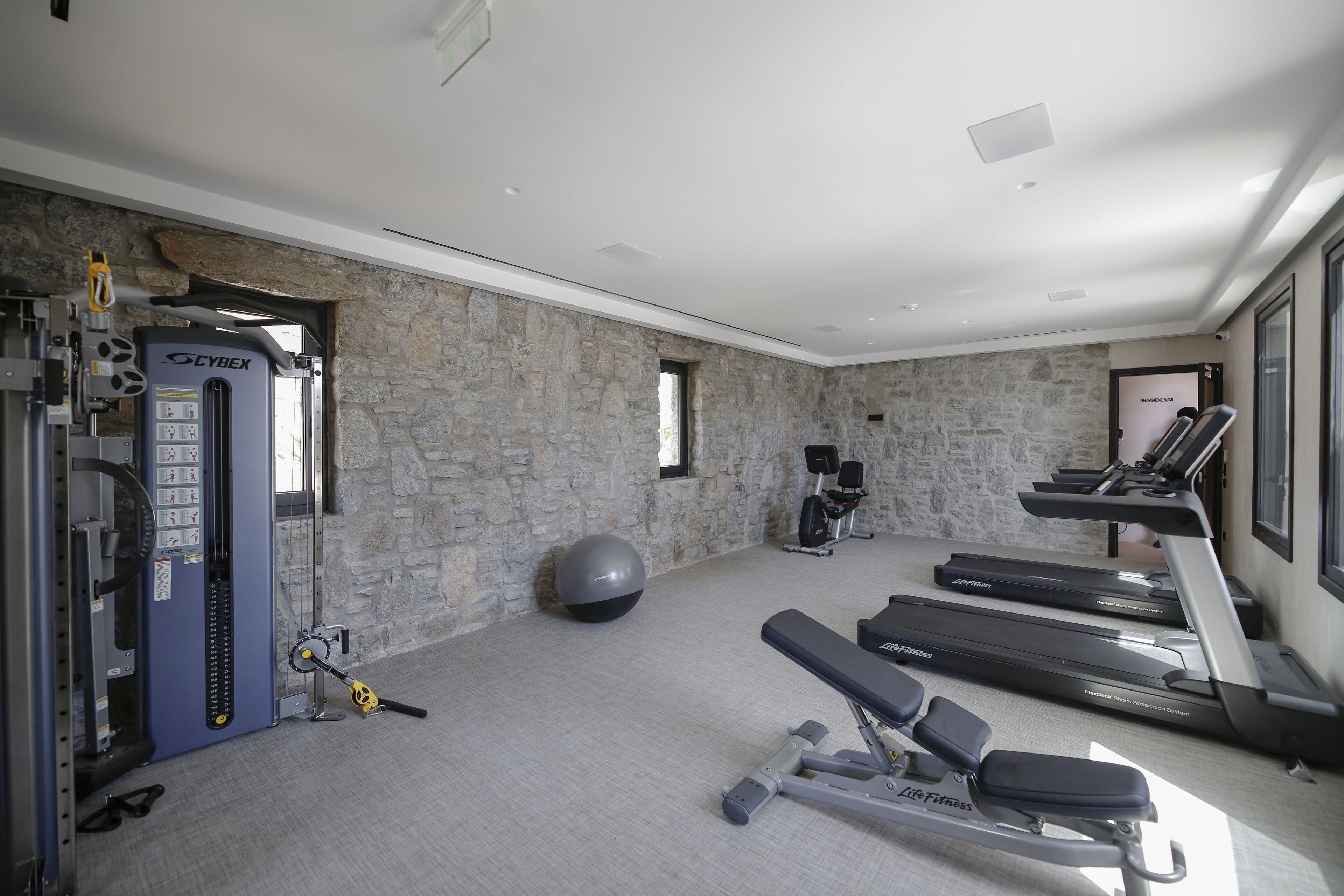 A gym with treadmills, a stationary bike, and weightlifting equipment.