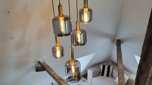 Une pièce de style « loft », avec un plafond en pente, des poutres apparentes et un mélange de meubles modernes et rustiques.