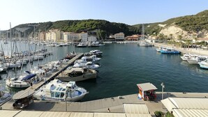 Uma marina com barcos atracados, um serviço de aluguel de barcos pequenos e edifícios ao fundo.