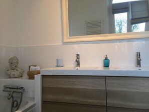 Een bad, een haardroger, handdoeken, toiletpapier