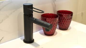 A modern kitchen with a black faucet and two red glass cups on the counter.