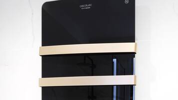 Eine schwarze, an der Wand befestigte Dusche mit digitaler Anzeige vor einer Marmorwand.