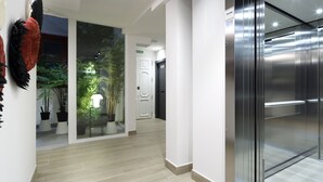 A modern elevator with a digital display, a glass door, and a metallic finish. - Pensión Ama Bilbao (Bilbao)