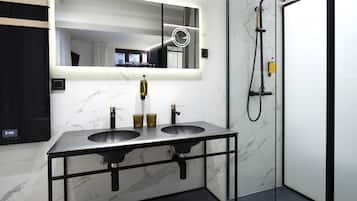 A modern bathroom with two sinks, a mirror, and a shower.