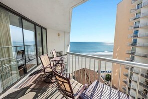 A balcony with a view of the ocean, furnished with chairs and a table. - 2 Bedroom Ocean Views, Pools, Sands, Ocean Annies! (Myrtle Beach)