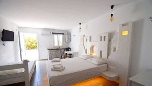 Ein modernes Schlafzimmer mit Bett, Nachttischen, Schreibtisch und Fernseher.