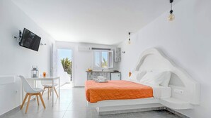 A modern bedroom with a bed, a desk, and a kitchenette. - Fantastic studio for 2 people with private (Mykonos)