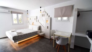 Une chambre à coucher moderne, comprenant un lit, une table de chevet, une chaise, un bureau et un téléviseur encastré.