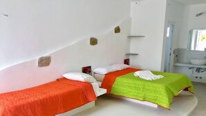 Ein Zimmer mit zwei Betten, einem Badezimmer mit Waschbecken und einem geschwungenen Boden.