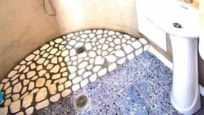 A bathroom with a shower, a sink, and a mirror. - Large studio apartment for 4 people, in a very (Mikonos)