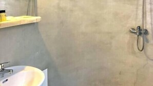 A bathroom with a sink, mirror, shower, and tiled floor. - Apartment for 4 people, located in Vrysi area, (Mikonos)