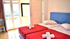 A hotel room with two beds, a sliding glass door, and a view of the outdoors. - Fantastic two-room apartment for 4 people, with (Mikonos)