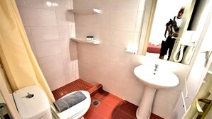 A bathroom with a toilet, sink, mirror, and shelves. - Fantastic two-room apartment for 4 people, with (Mikonos)