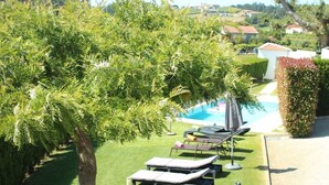 A poolside area with lounge chairs and a hammock. - Villa 315 Fully Renovated Typical Stone House (Barcelos)