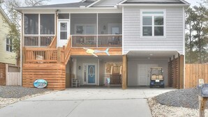 Ein zweistöckiges Haus mit Balkon, Garage und überdachter Eingangszone.