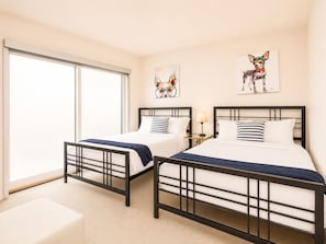 A hotel room with two beds, a large window, and artwork on the walls. - Upscale 3BR Penthouse by CozySuites (Indianapolis)
