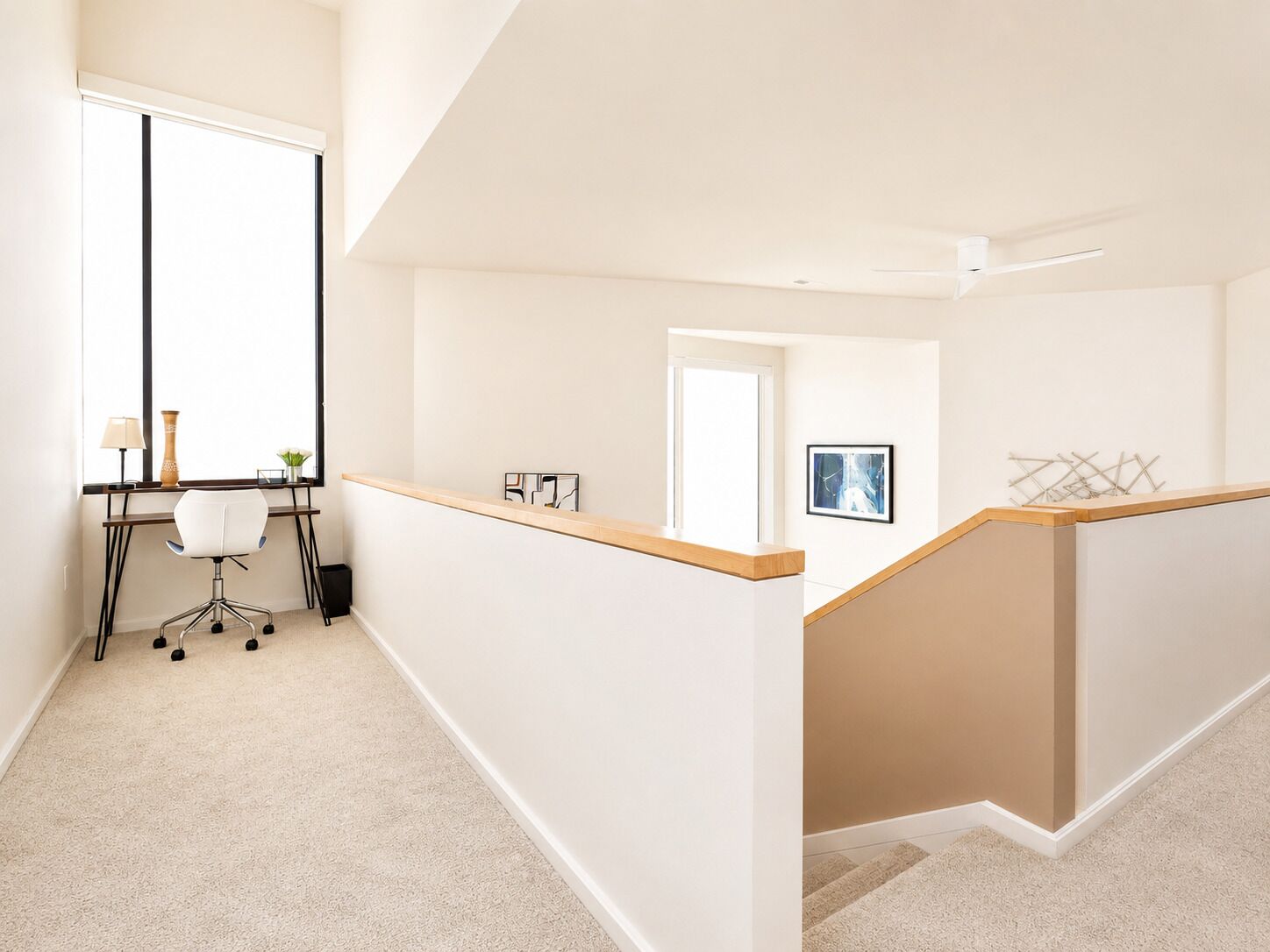 Un intérieur moderne avec un bureau, une chaise et une œuvre d’art accrochée au mur.