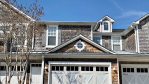 A two-story house with a garage, a small attic window, and a chimney.