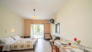 Een kamer met een bed, een gedekte tafel en uitzicht door een geopende deur.