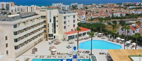A hotel with a pool area, including a water slide and lounge chairs.