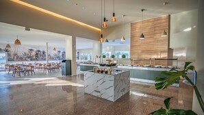 A spacious indoor area with a marble island, seating, and a kitchen area. - Toxotis Hotel  (Paralimni)