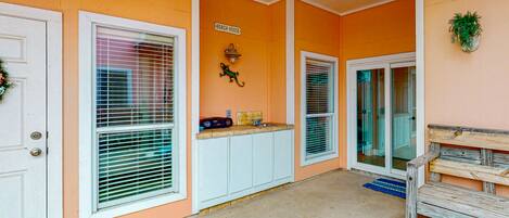 A beach-themed exterior with a sign reading "BEACH HOUSE," a small shelf with items, and a wooden bench.