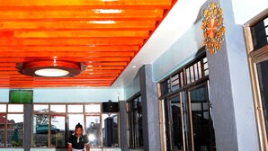 A modern interior with a wooden ceiling, a large clock, and large windows. - Pinnacle Hotel Mbarara (Mbarara)