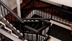 A staircase with black railings and a potted plant on the landing. - Pinnacle Hotel Mbarara (Mbarara)