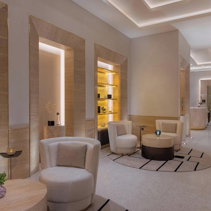 A modern interior with a central seating area, built-in shelving, and a well-lit hallway.