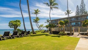 A hotel with a pool area, lounge chairs, and a view of the ocean. - Enjoy A/C, walk to beach/dining/shopping, from the Heart of Kapa'a! (Kapaa)