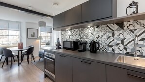 A modern kitchen with a large window, a coffee machine, and a microwave. - Destiny Scotland Market St Apartments (Edinburgh)