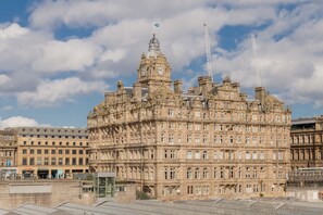 A historic building with multiple floors, large windows, and a prominent clock tower. - Destiny Scotland Market St Apartments (Edinburgh)