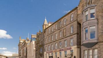A street with historic buildings, including a restaurant named "The Doric Bistro" and a shop called "The Helries."