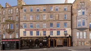 A historic building with multiple ground-floor establishments including 'The Doric Bar & Restaurant' and 'The Hebrides'. - Destiny Scotland Market St Apartments (Edinburgh)