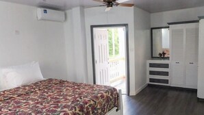 A bedroom with a bed, a ceiling fan, a wardrobe, and a door leading to a balcony. - The Best of Home - Tranquil, Comfort & Convenient (Beausejour)