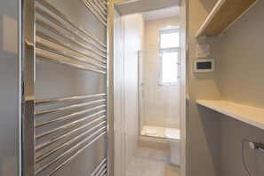 Un bagno con doccia, WC e pannello di controllo a parete.