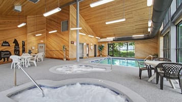 Ein Hallenbad mit mehreren Bahnen, Sitzgelegenheiten und Holzvertäfelung.