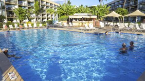 A swimming pool with clear blue water, surrounded by lounge chairs and palm trees. - Where Serenity Finds You Kihei Remodeled 1BR Condo Private Lanai and Pool (Kihei)
