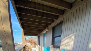 Une terrasse en bois avec des sièges extérieurs et un espace abrité.