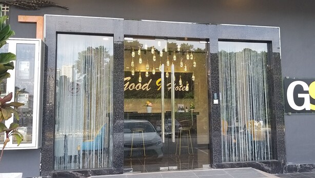 A modern building with a glass entrance, a sign reading "Good Food," and a logo with the letters "G9." - Good 9 Hotel, Cahaya Kota Puteri (Masai)