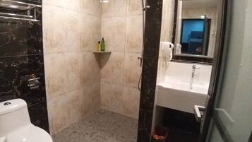 Un baño con inodoro, ducha y lavamanos.