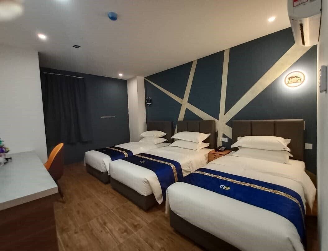 Una habitación de hotel con dos camas, un escritorio y una silla.