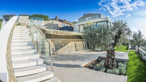 A modern house with a stone staircase, a glass railing, and a well-maintained garden. - Villa Fortezza - pool, sauna, Jacuzzi and countryside views by MyWaycation (Buje)