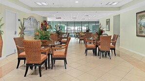 A spacious dining area with wicker chairs and tables, large windows, and tropical decor. - 2 BR 2 BA Unit with Beautiful Bay Views (Ocean City)