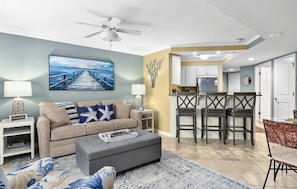 Relax in this stylish living space, featuring a comfortable sofa, a dining area, and a fully equipped kitchen.
