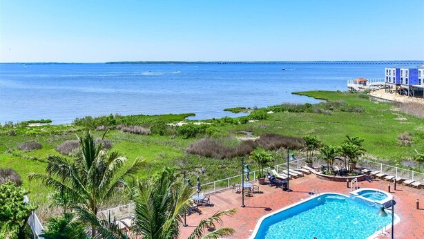 A pool area with a view of the ocean and a pier in the background. - 2 BR 2 BA Unit with Beautiful Bay Views (Ocean City)