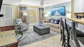 A living room with a sofa, armchair, ottoman, and a glass coffee table. - 2 BR 2 BA Unit with Beautiful Bay Views (Ocean City)