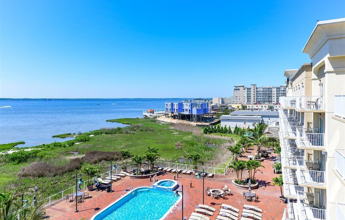 Een resort met een zwembad, ligbedden en uitzicht op de oceaan.
